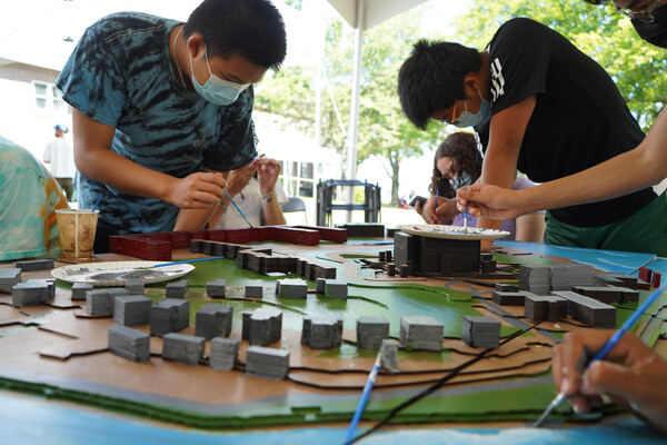 Teenage students working on a scale design model.
