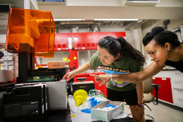 Scientists Erynn Johnson and Aja Carter use a 3D printer to make shell shapes