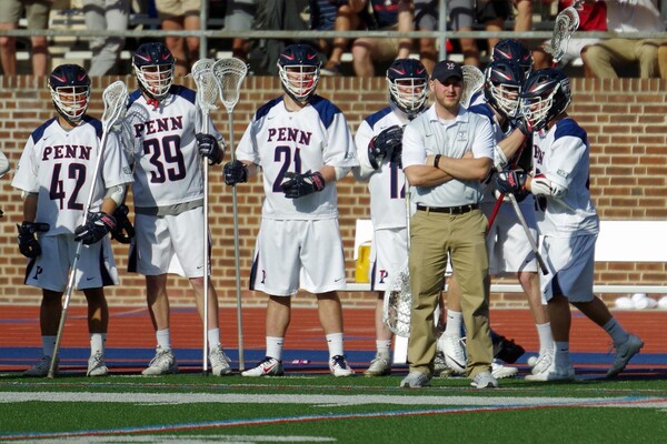 Anthony Erz oberserves gameplay from the sidelines during a men's lacrosse game at Franklin Field.