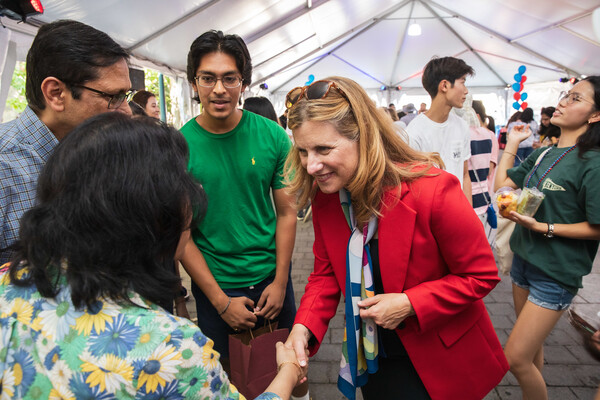 Penn President Liz Magill shakes hands with a new student’s parent.