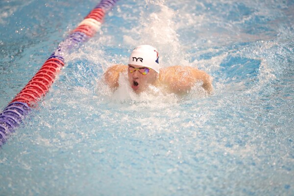 Matt Fallon comes up for air while doing the breaststroke during a meet in the pool.