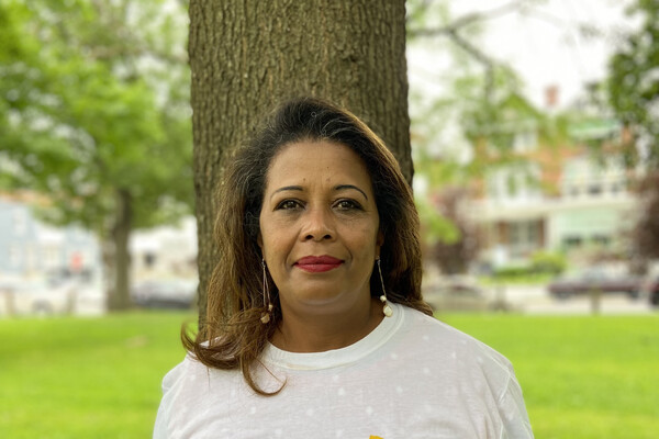 A person, Helaine Heggs, standing outside in front of a tree.