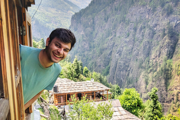 Udai Bhardwaj leans out a window in the mountains.
