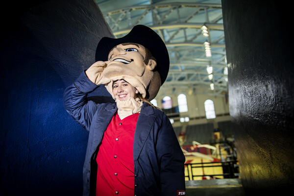 Sophia Zehler removes the Quaker mascot head in costume at the Palestra.