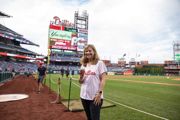 Liz Magill holds a baseball on the field of Citizens Bank Park