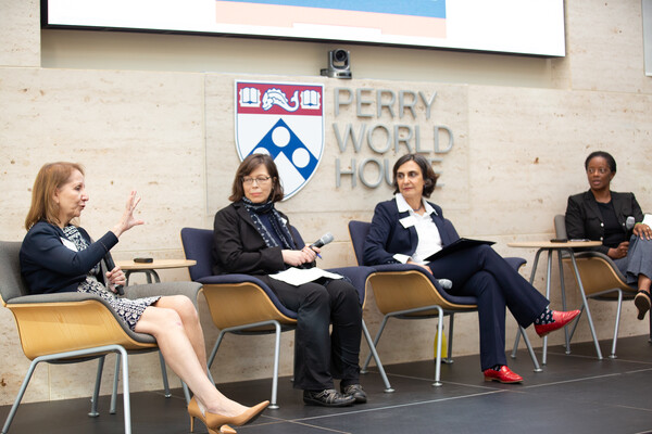 Antonia M. Villarruel addresses the audience while Emily Hannum, Tulia Falleti, and LaShawn Jefferson look on. A sign behind the group reads: Perry World House.