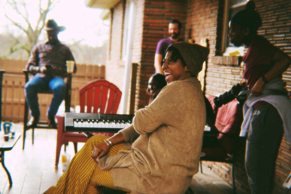 Musicians from the Black Opry Revue performing on a porch