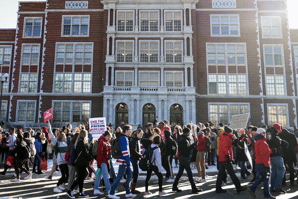 A group of students demonstrating in front of a school building.