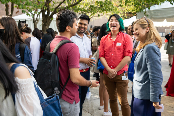 Penn President Liz Magill speaks with three graduate and professional students outside on Penn’s campus.