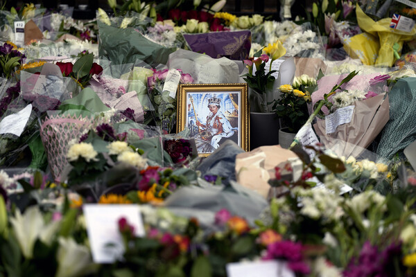 Framed photo of Queen Elizabeth sits amid bouquets of flowers 