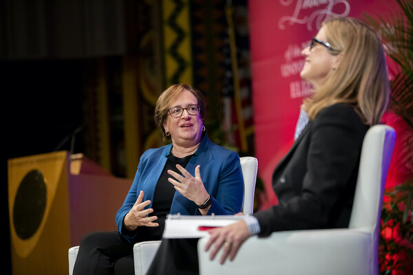 Justice Elena Kagan gestures to a smiling Penn President Liz Magill on the stage at Irvine Hall