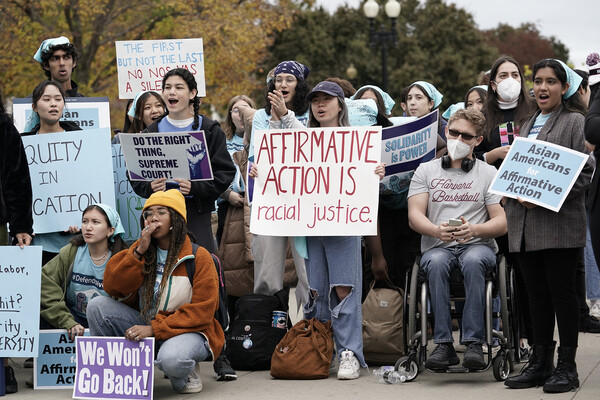 Students holding signs in favor of affirmative action in protest at Supreme Court.