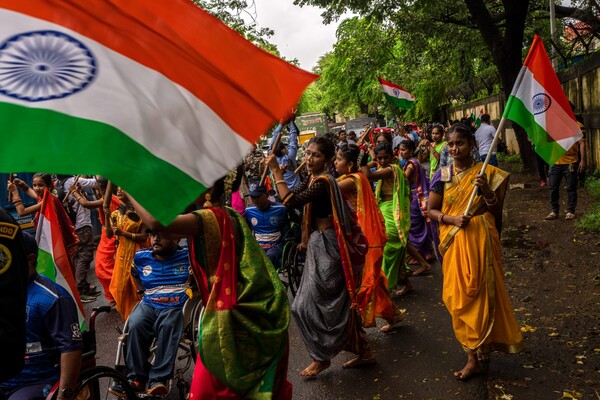 Indians celebrating 75 years of India's independence in the street, holding flags.