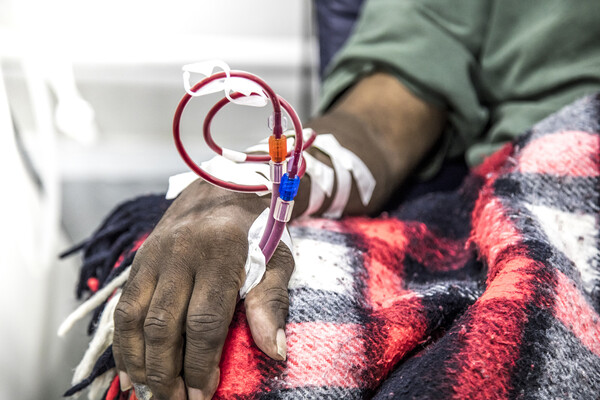 Hospital patient with a blood transfusion in arm.