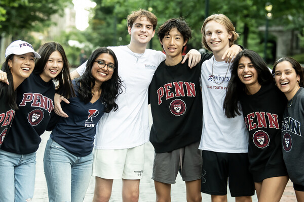 Eight high school students smile for the camera on Penn’s campus.