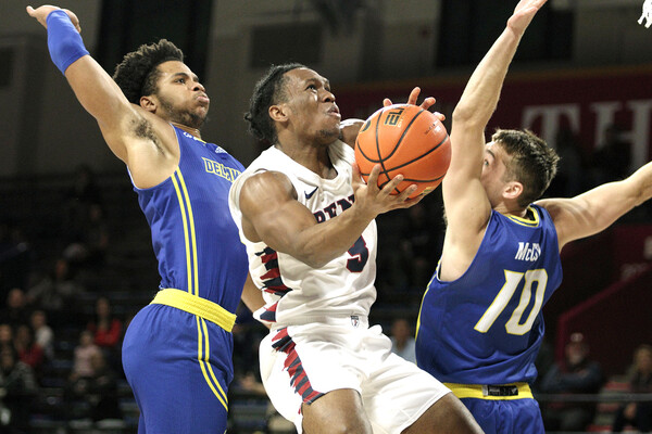 Jordan Dingle goes up for the shot in between two Delaware defenders during a game at The Palestra.