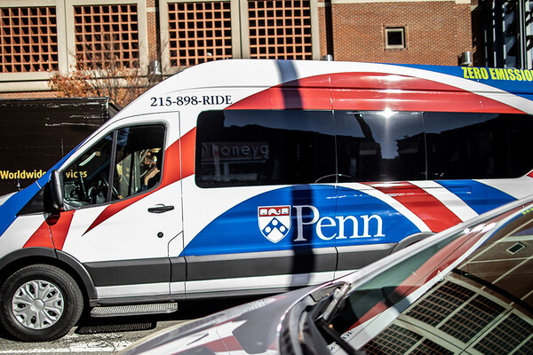 A passenger van driving between two cars