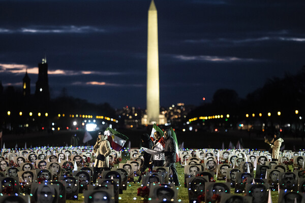 Protesters carrying Iranian flags walk through the National Mall in Washington, D.C., which is dotted with black and white photos of Iranians allegedly killed by their government.