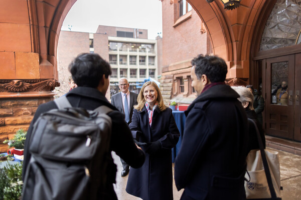 Liz Magill greets two people at the entryway to Fisher Fine Arts Library.