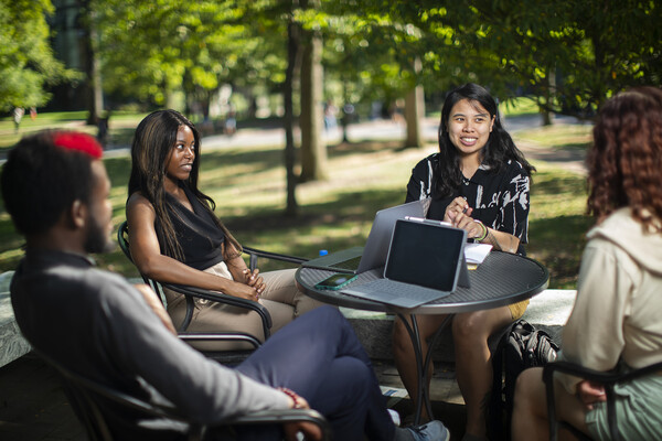 students sitting around a table outside on locust walk