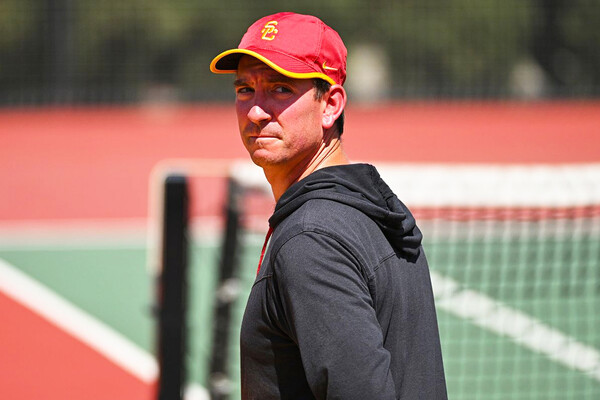Wearing a USC hat, Rich Bonfiglio stands on the tennis court.