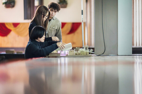 June Lin, Jessica Lin, and Jason Cornelison preparing a model building at the Weitzman School. 