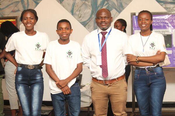 Four peple standing, posing for the camera. Three are students at  Kamuzu University of Health Sciences. The fourth is a professor there, Adamson Muula.