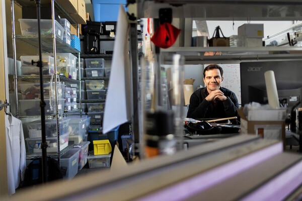 Devin Carroll sits at his desk.