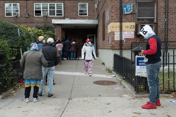 A line of people waiting outside a polling place.