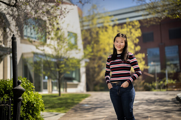 Jing Jing Piriyalertsak stands in front of Perry World House.