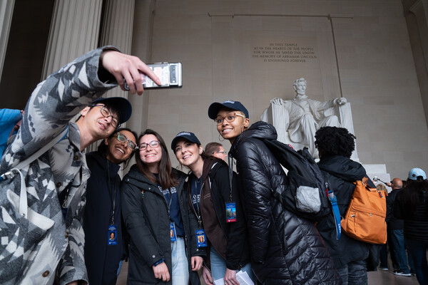 students taking a selfie at the Lincoln memorial