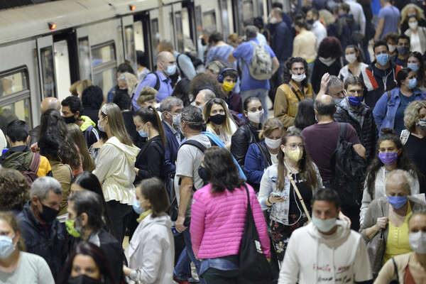 Subway train passengers with protective masks crowding to get on and off subway station platform on Metro station.