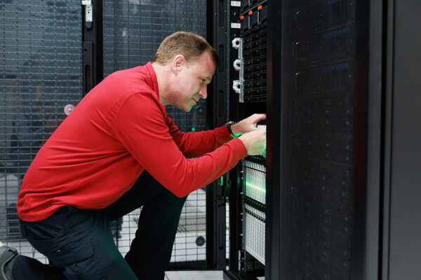 Gregory Bowman kneeling down in front of a server.