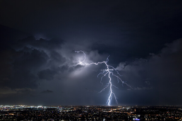 Photo of lightening striking a city at night.