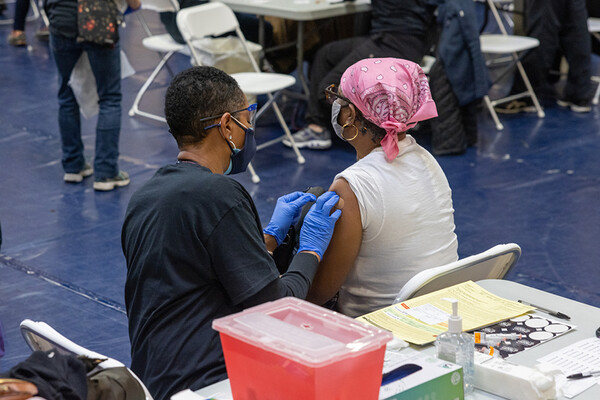 A medical worker gives a person a Covid vaccine.