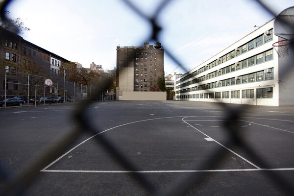 An empty schoolyard in a city.