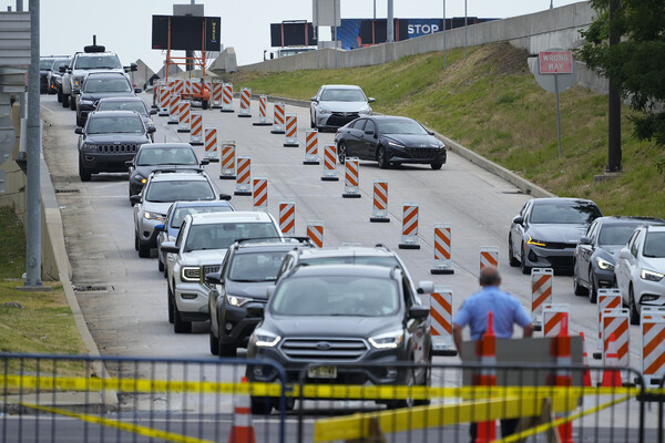 Cars wait in a line to divert from an exit roadway. 