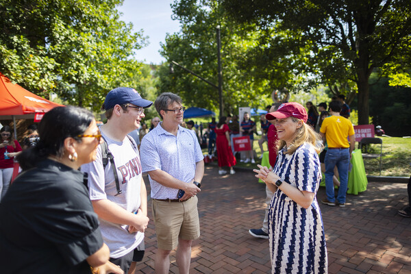 Penn President Liz Magill greets a student and their family on Locust Walk.