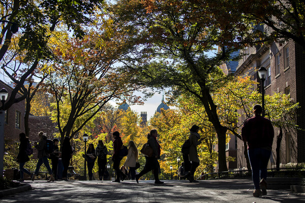 students walking on locust walk in autumn