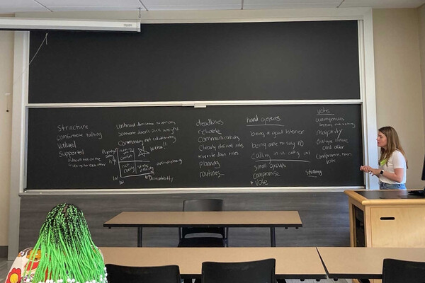Brittany Zulkiewicz teaches at a blackboard in a high school classroom.