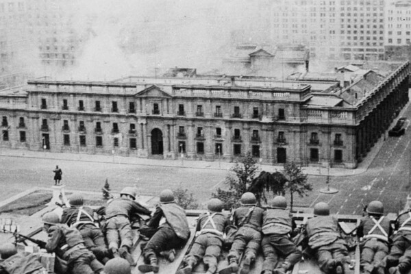 A row of soldiers lying on their stomachs take cover as La Moneda, the Chilean presidential palace, is bombed. 