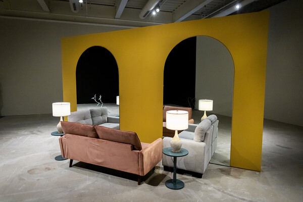 Love seats and side tables placed in front of arched mirrors. 