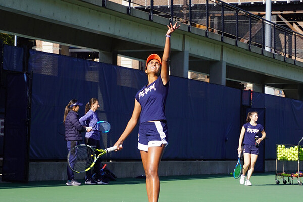 Esha Velaga throws the ball in the air and prepares to serve during a game.