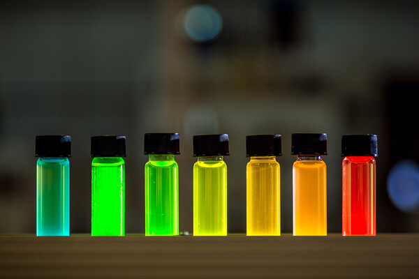 Seven vials filled with liquid water and quantum dot semiconductors.   