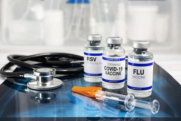 Three vials of vaccines: RSV, COVID, and flu.