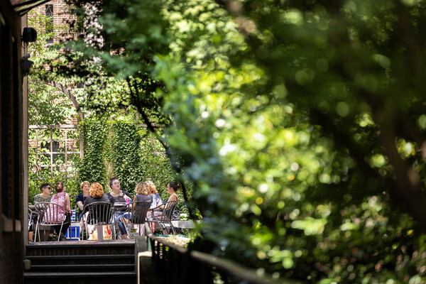 A group of people seated outside on Penn’s campus in summer.