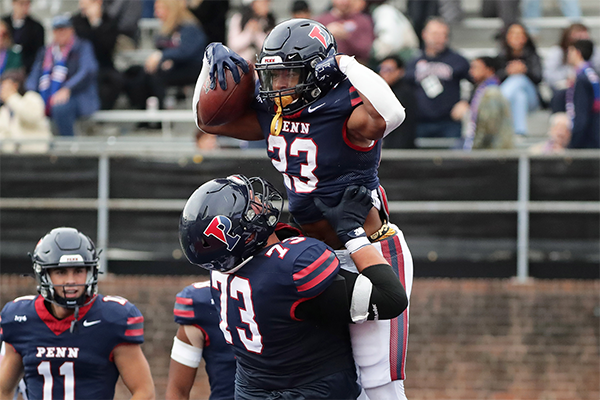 Malachi Hosley flexes while a teammate lifts him in the air after scoring a touchdown against Cornell.