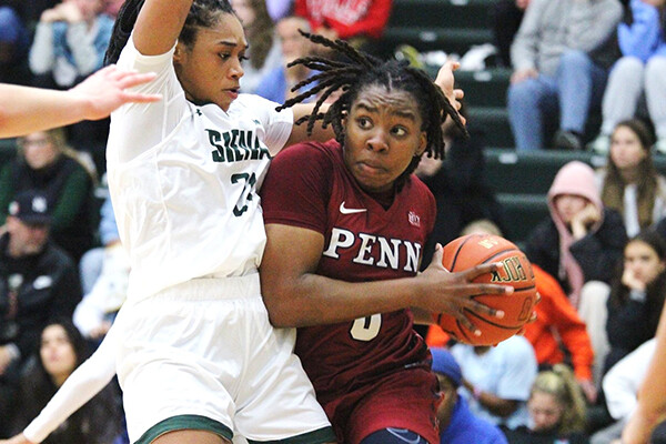 Forward Jordan Obi makes a move with the ball while guarded by a Siena defender.