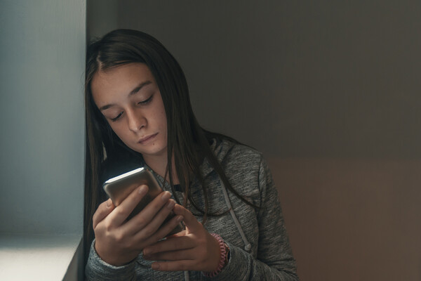 A distressed teen with a smartphone.