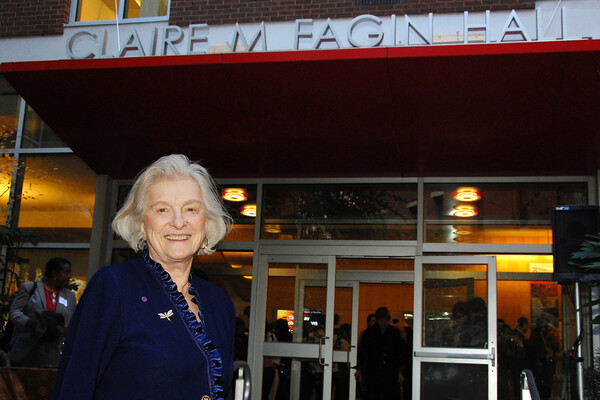 Claire Fagin stands in front of Claire M. Fagin Hall on Penn campus.
